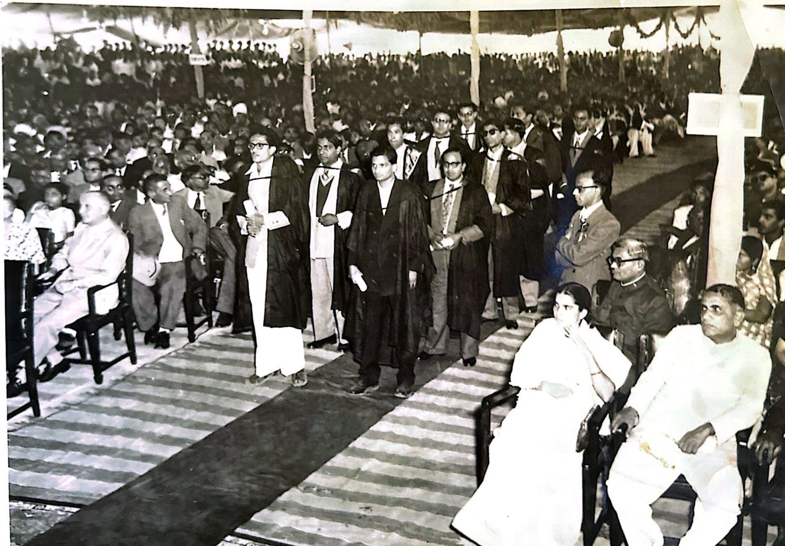 Graduates in academic gowns at an outdoor convocation ceremony