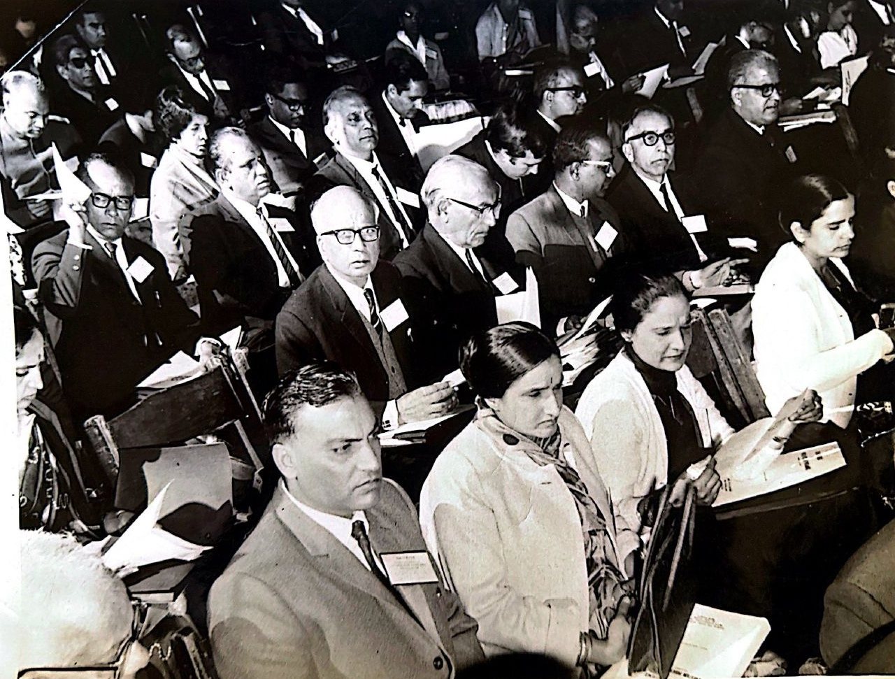 Delegates seated in rows at a medical conference, reading papers